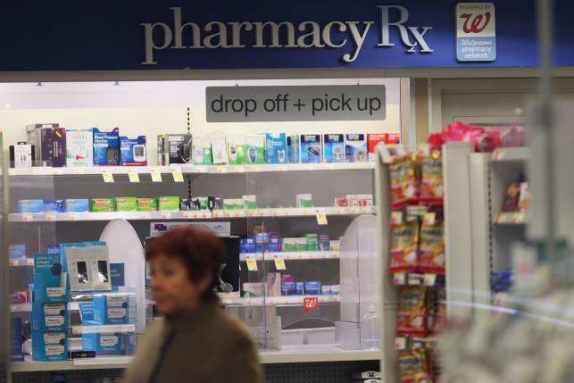 Woman walks in front of pharmacy counter