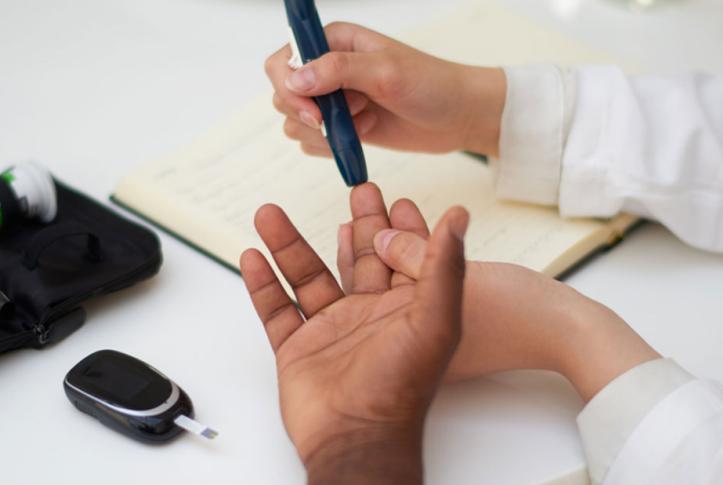 doctor testing blood of diabetes patient