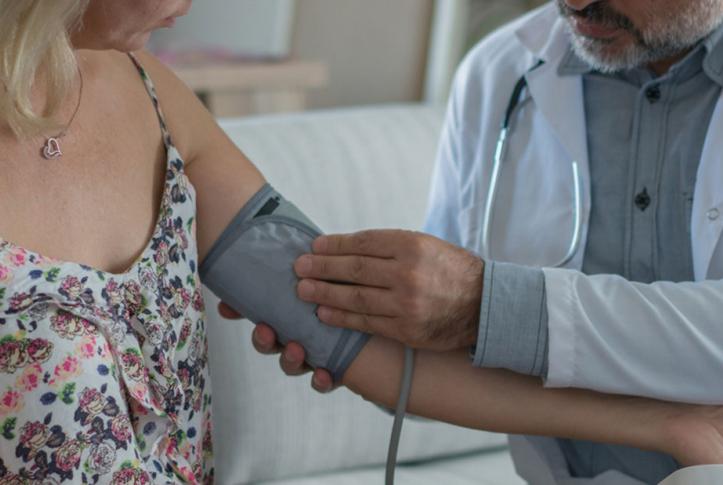 doctor taking patient's blood pressure