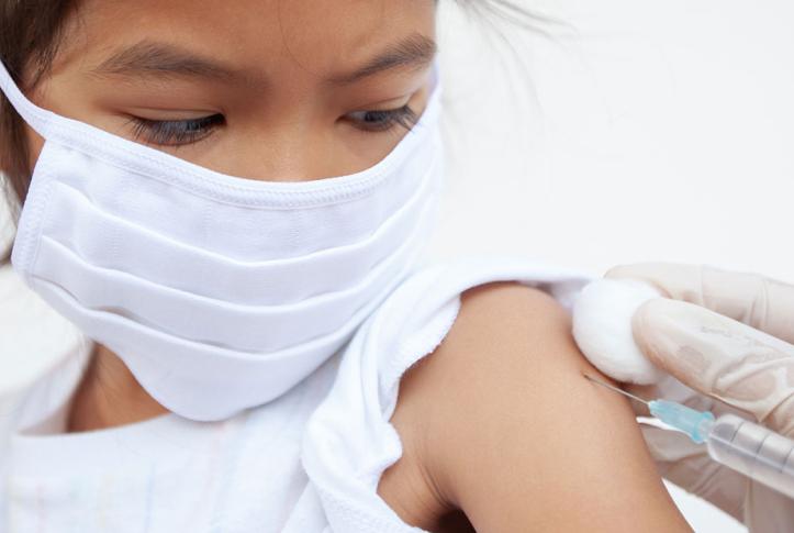 masked girl gets immunization