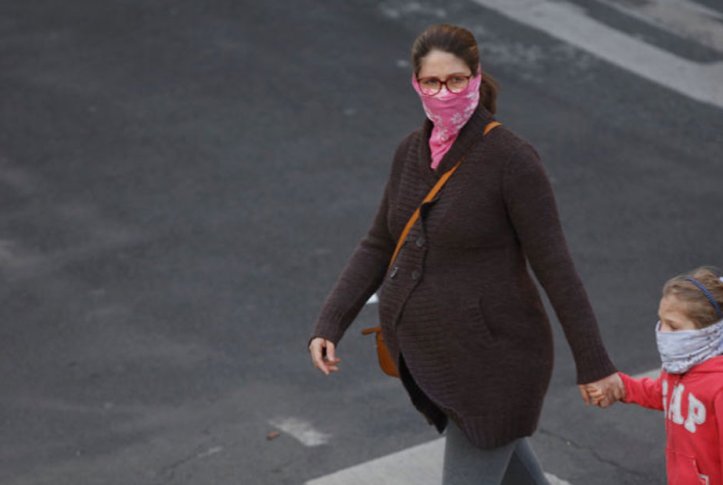 pregnant woman walking with child and masks during COVID-19 outbreak