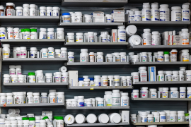 Wall of prescription drug bottles on shelves