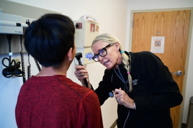 Physician assistant looks in patient's mouth